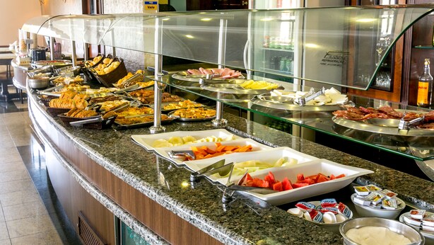 A buffet with various food items and condiments. - Hotel Exclusivo (Sao Jose dos Pinhais)