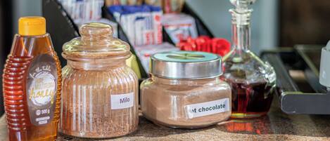 A kitchen counter with various food items including honey, flour, and chocolate.
