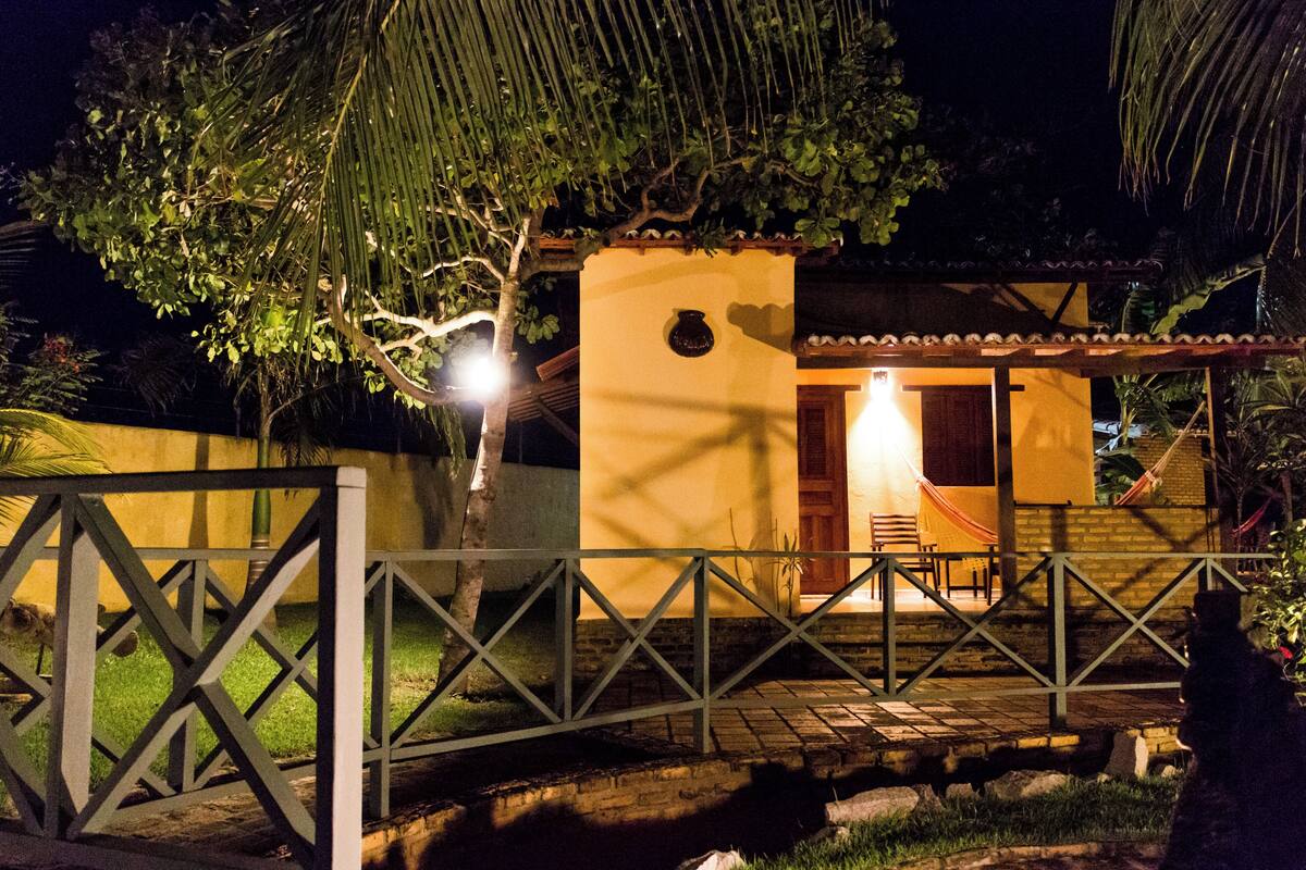 A small, yellow building with a tiled roof and a wooden door.