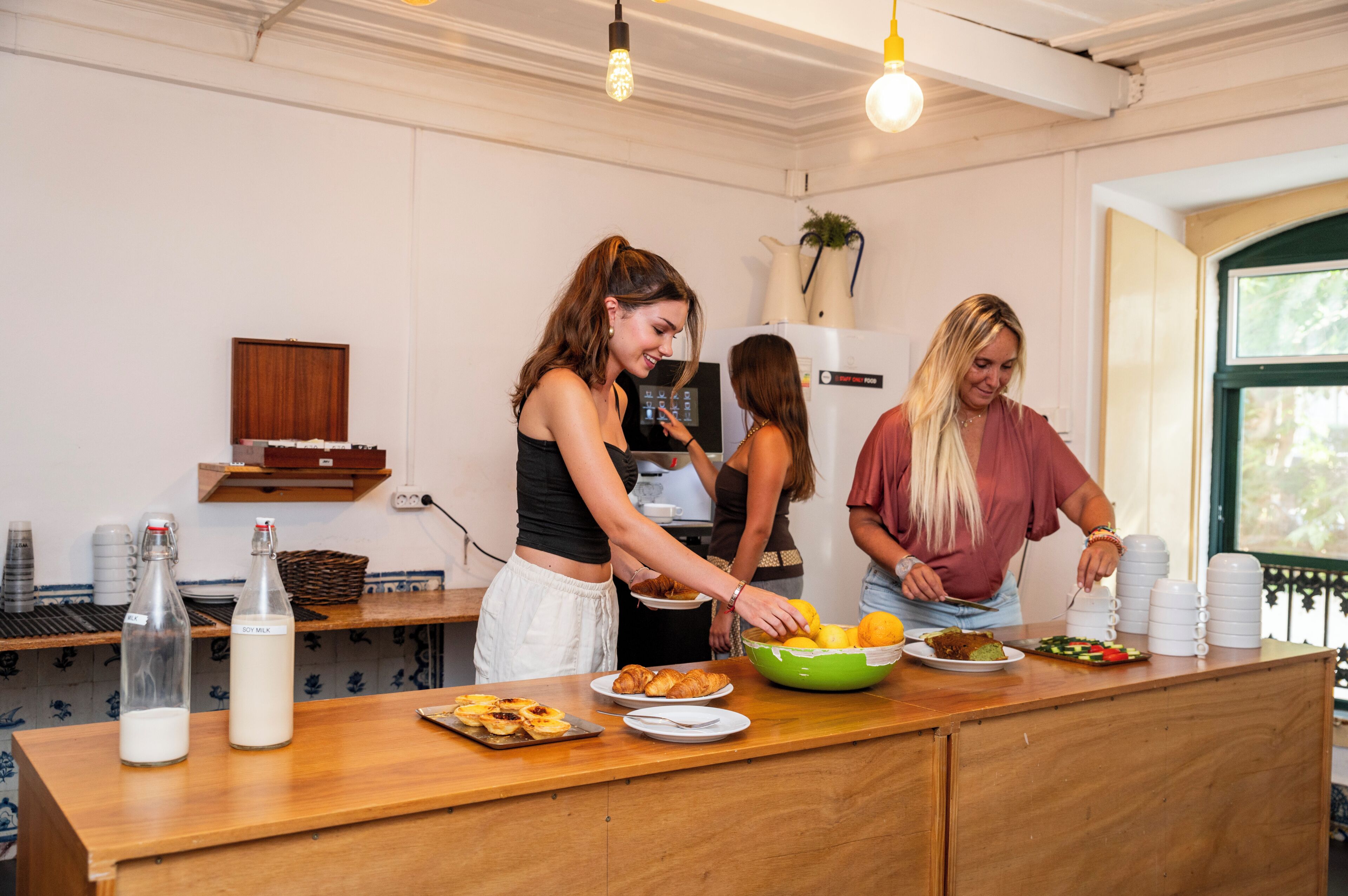 A kitchen area with a wooden countertop, a bottle of milk, and a bowl of lemons.