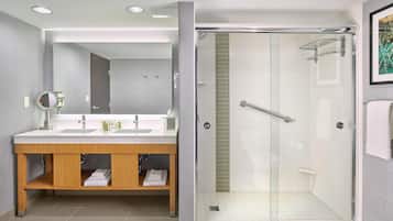 Une salle de bain moderne avec une douche à parois de verre, un meuble-lavabo avec un miroir et un évier.