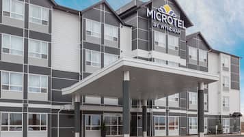 A modern Microtel by Wyndham hotel with a covered entrance, large windows, and a flat roof.