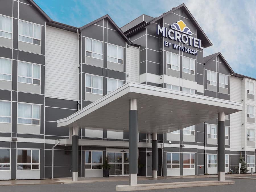 A modern Microtel by Wyndham hotel with a covered entrance, large windows, and a flat roof.