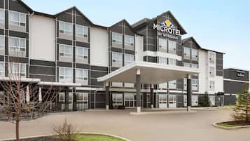 Experience the hotel's modern design, featuring a symmetrical facade and landscaped entrance.