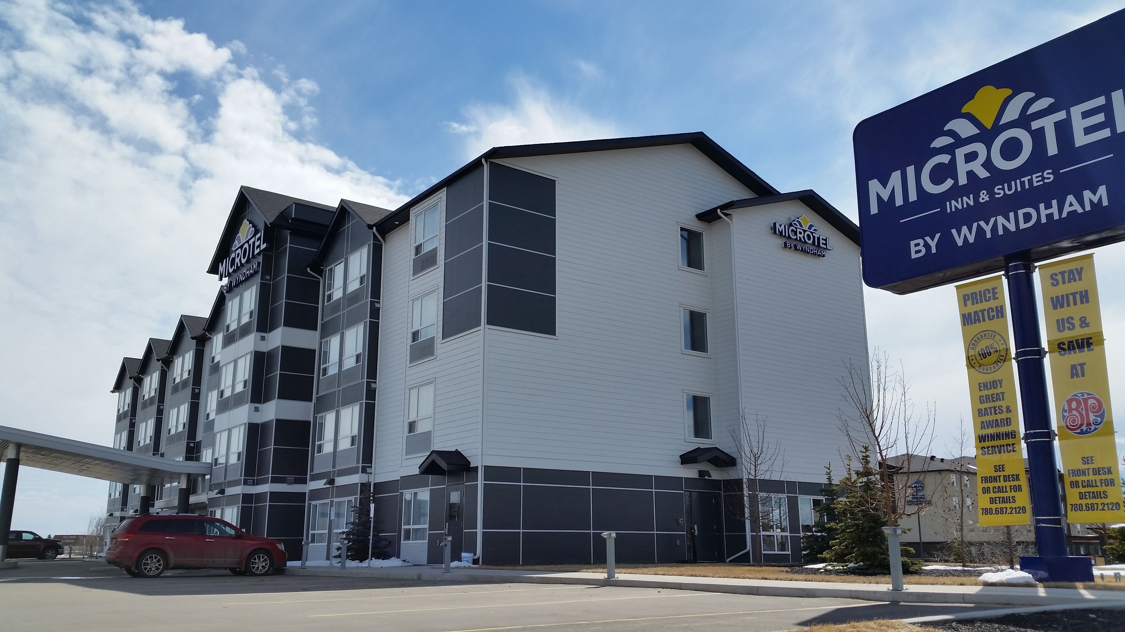 A Microtel Inn & Suites building with a modern design, featuring a mix of dark and light panels on the exterior.