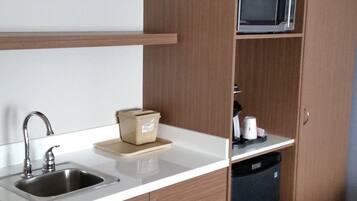 A compact kitchen with a sink, a microwave, and a dishwasher.