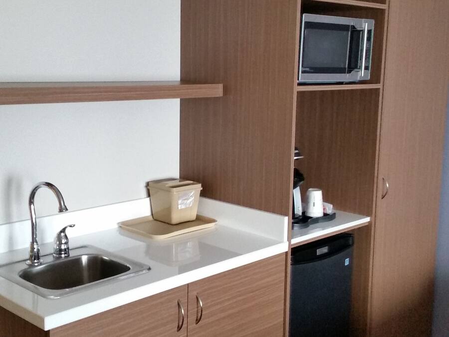 A compact kitchen with a sink, a microwave, and a dishwasher.