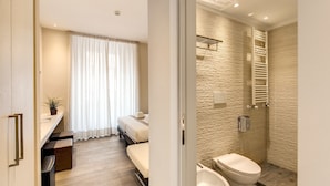 A modern hotel room with a bed, bedside table, and a bathroom with a bathtub and toilet. - Ecce Roma Suites (Rome)
