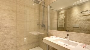 A modern bathroom with a glass shower enclosure, a large mirror, and a white sink. - Ecce Roma Suites (Rome)