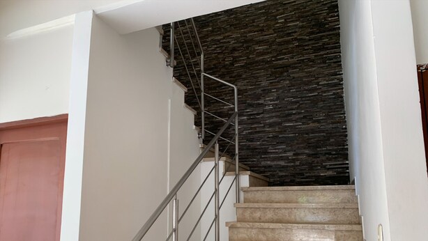 A staircase with a metal railing and a stone wall at the top. - Hotel Papagayo (Veracruz)