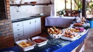 A buffet setup with various food items and a brick wall. - Pousada Corais do Sul (Tibau do Sul)