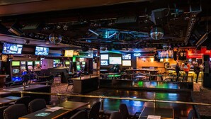 A casino with multiple gaming tables, slot machines, and a bar area. - Travelodge by Wyndham Winnipeg Airport West (Winnipeg)