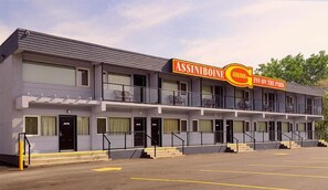 Un motel de dos pisos con un letrero que dice "ASSINIBOINE GORDON INN ON THE PARK".
