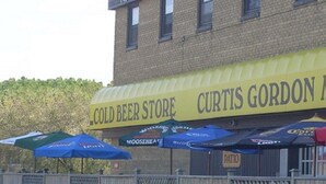 A building with a yellow awning labeled "Cold Beer Store Curtis Gordon." - Curtis Gordon Motor Hotel (Winnipeg)
