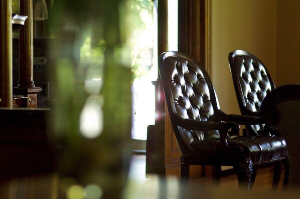A room with two leather armchairs and a wooden table.