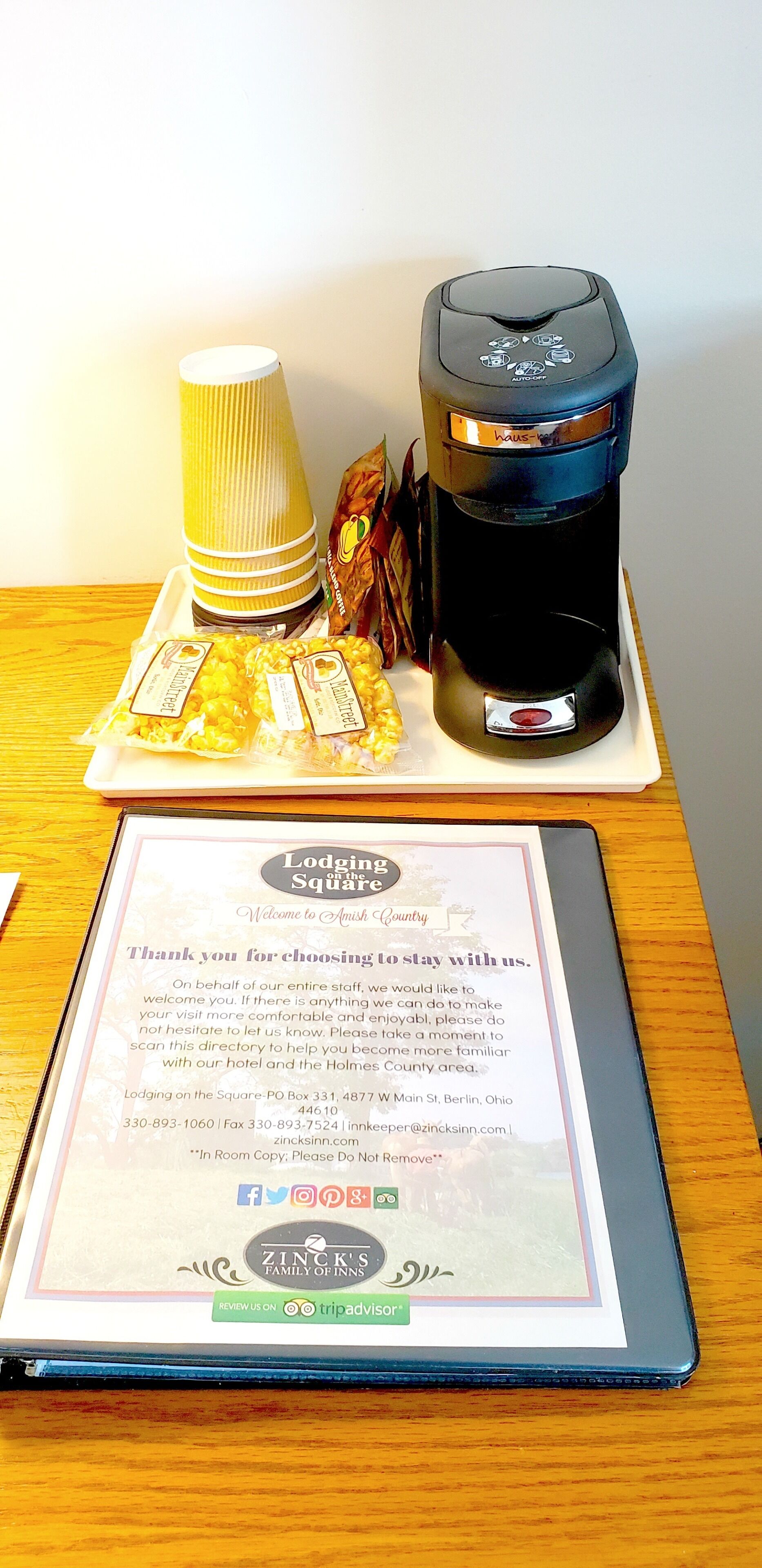 Una cafetera, bolsas de palomitas y un cartel de bienvenida sobre una mesa.