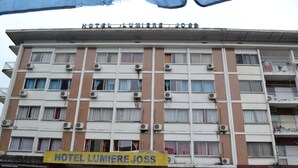 Un edificio de varios pisos con un letrero que dice "HOTEL LUMERE JOSS".
