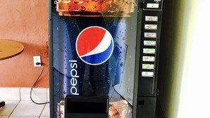 A vending machine with a Pepsi logo, a price tag of $1.25, and a calorie count display. - Greystone Motel (Hillsboro)