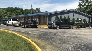 A building with a blue roof and a large garage door. - Greystone Motel (Hillsboro)