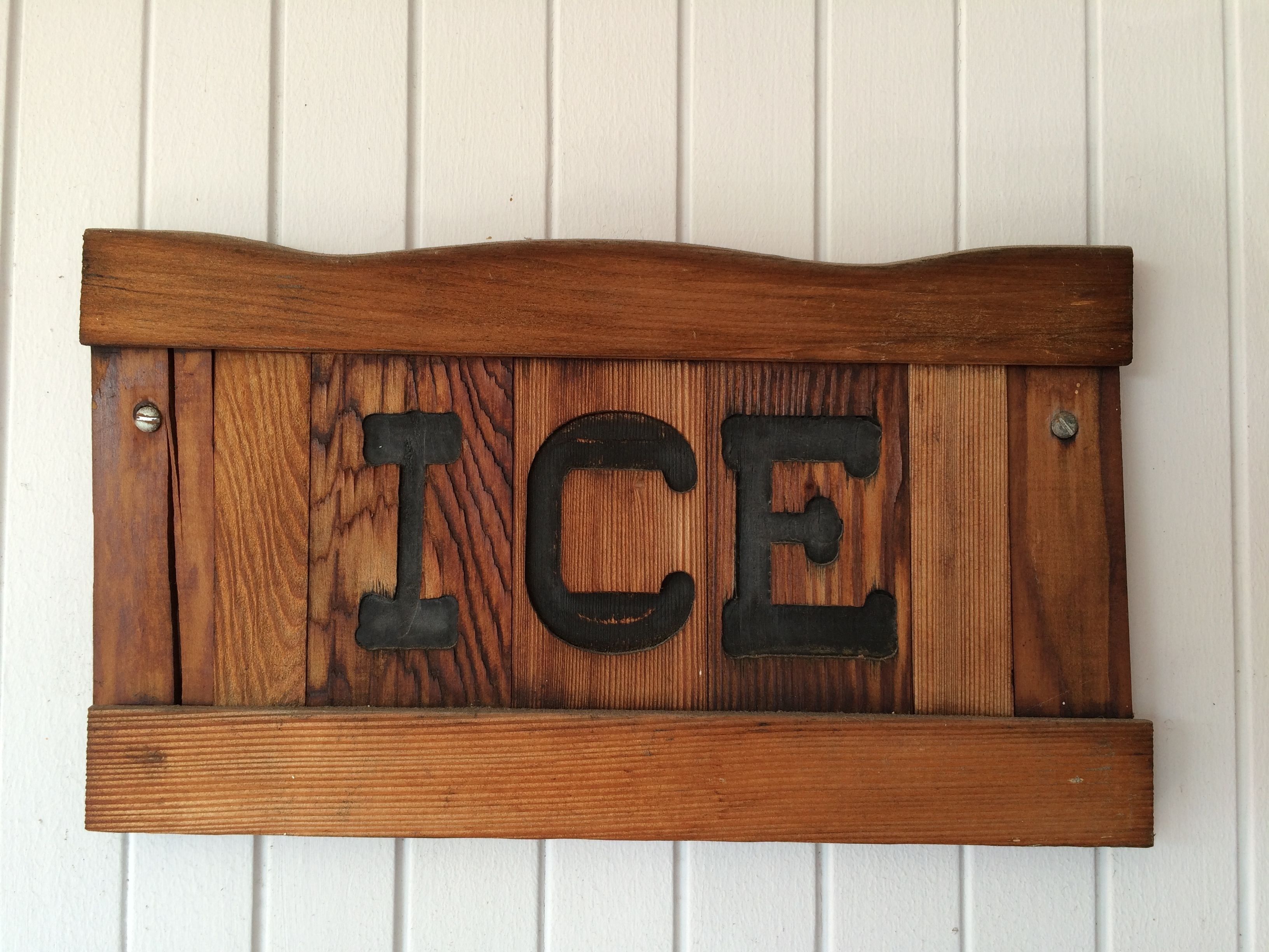 A wooden sign with the word "ICE" in large, dark letters.