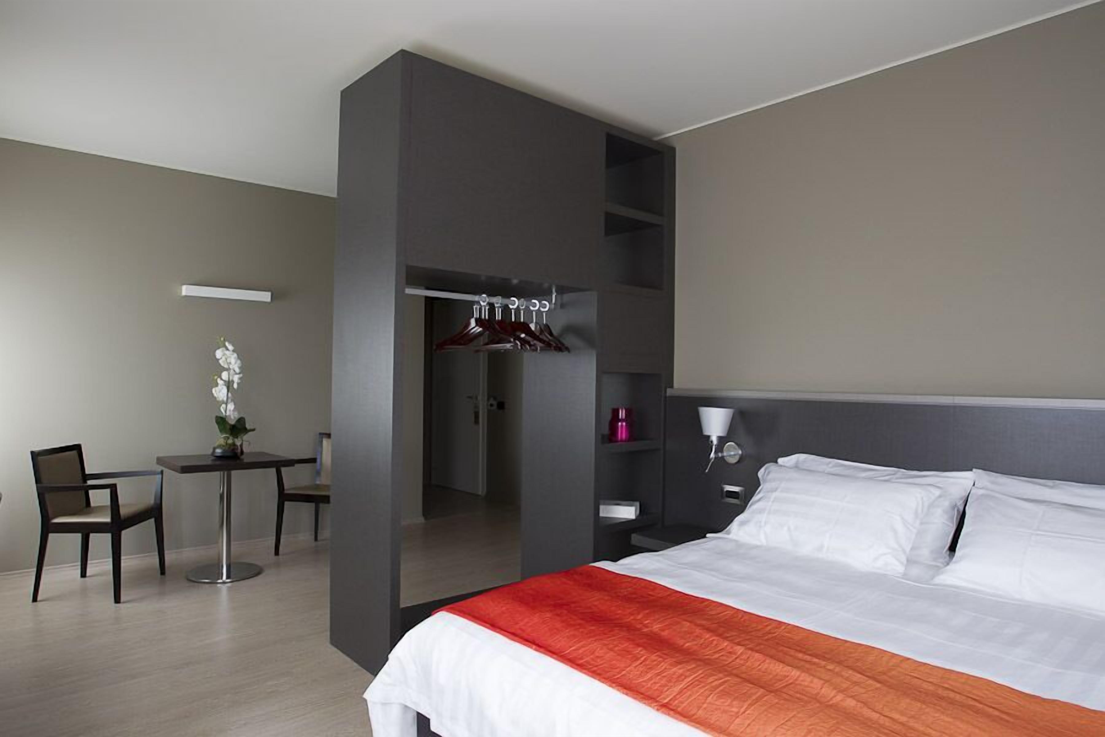 Una habitación de hotel moderna con una cama, un escritorio y una silla.
