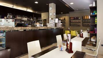 A modern bar area with a counter, seating, and a wine display.