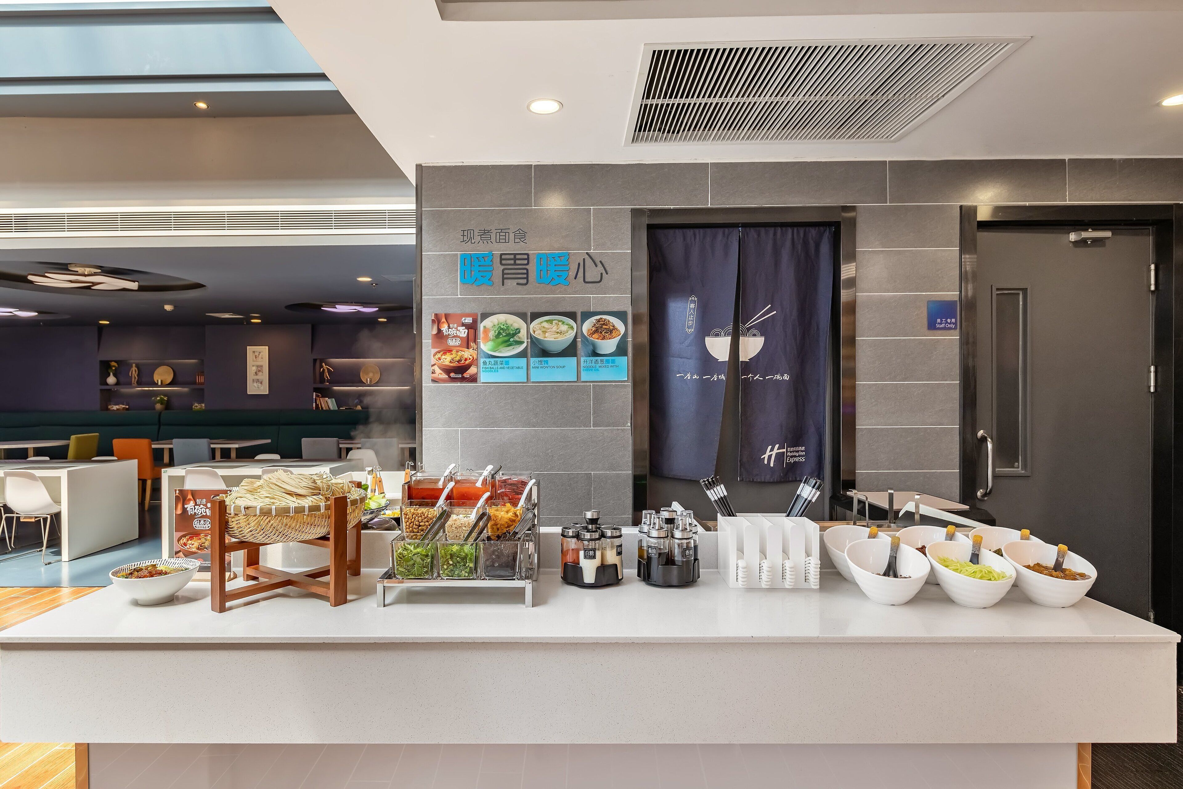 Un restaurant moderne doté d’un buffet, de différents récipients contenant de la nourriture et d’un panneau affichant le menu.