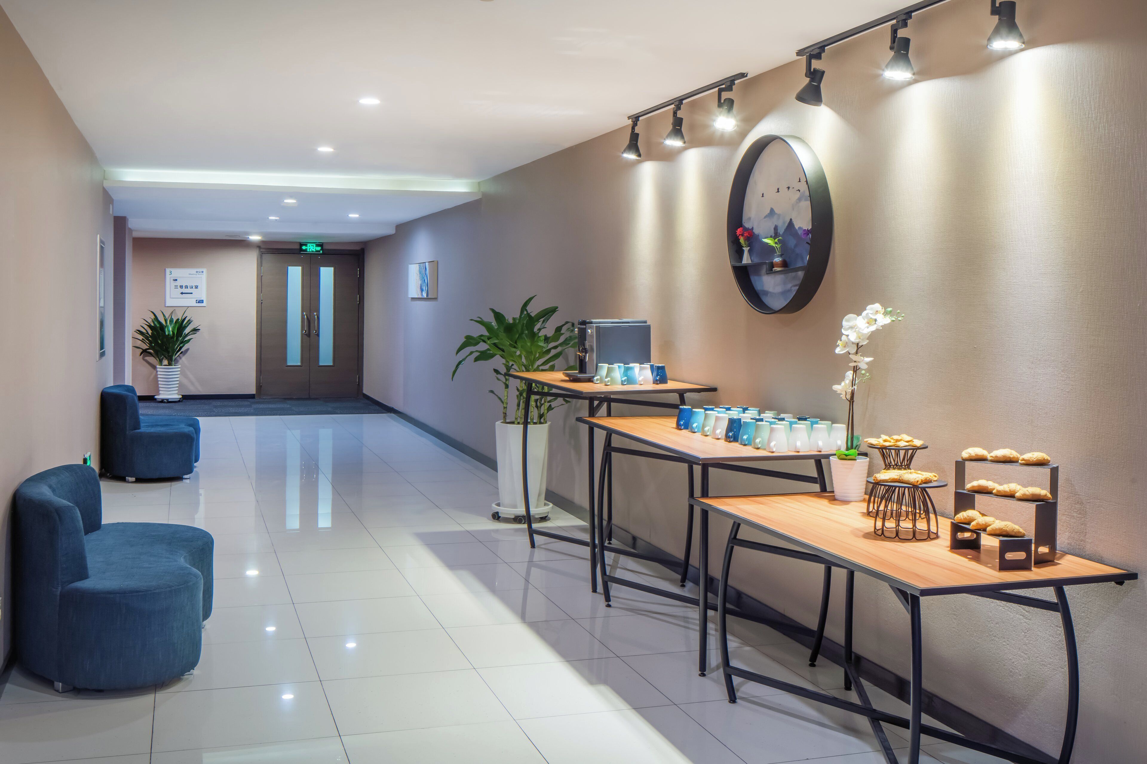 A hotel lobby with seating, a reception desk, and a wall-mounted clock.