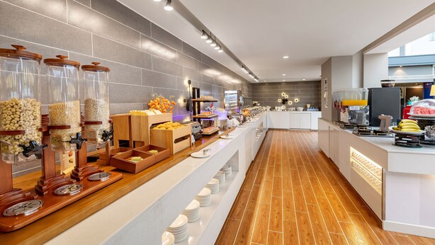 A modern buffet setup with various food items and a long counter. - Holiday Inn Express Shenyang North Station by IHG (Shenyang)