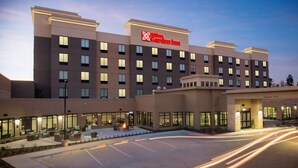 A multi-story hotel with a clear entrance, outdoor seating area, and a well-lit facade. - Hilton Garden Inn Longview (Longview)