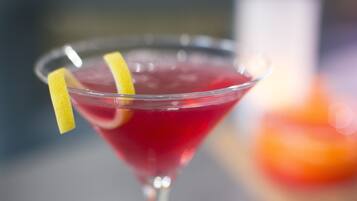 A cocktail in a martini glass with a lemon garnish.