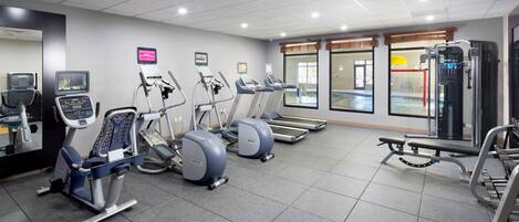 Una palestra con tapis roulant, macchinari ellittici e attrezzature per l'allenamento con i pesi.