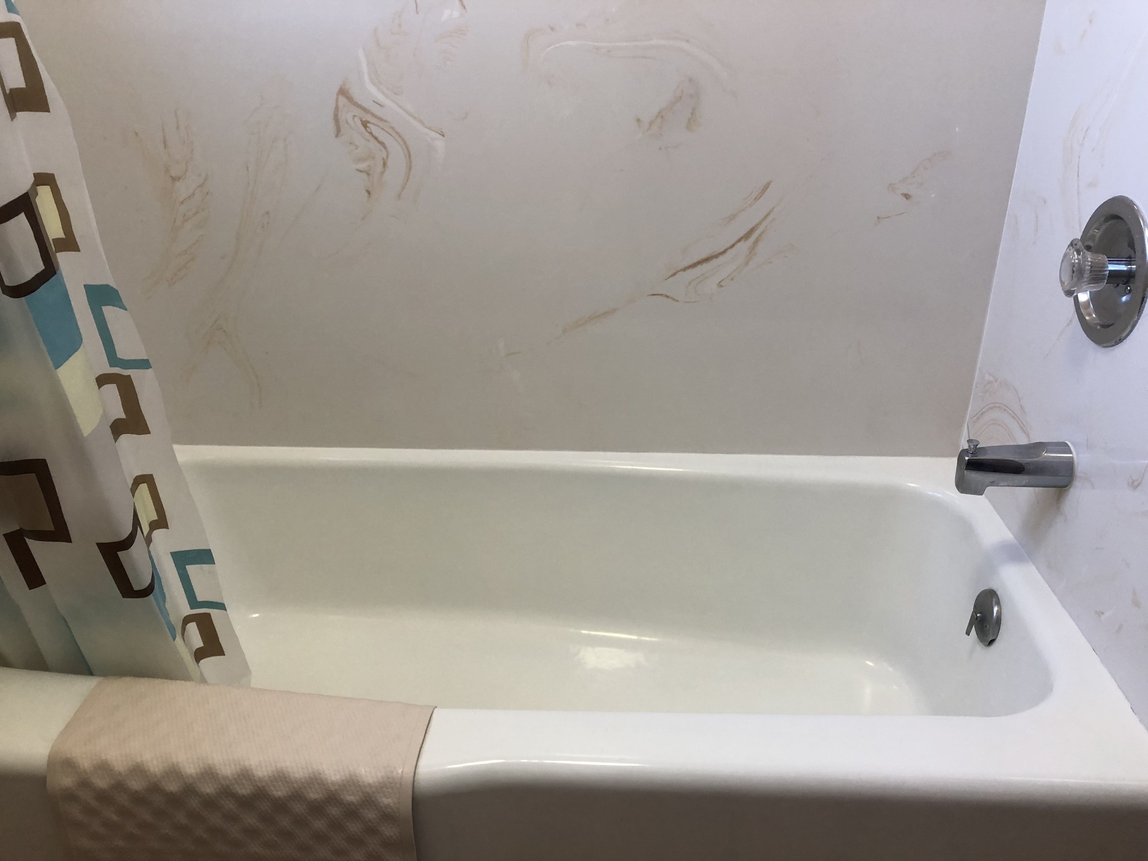 Un baño con una bañera, cortina de ducha y un toallero.