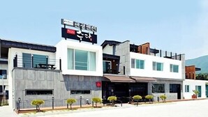 Un edificio moderno con un letrero llamativo, amplias ventanas y techo plano.
