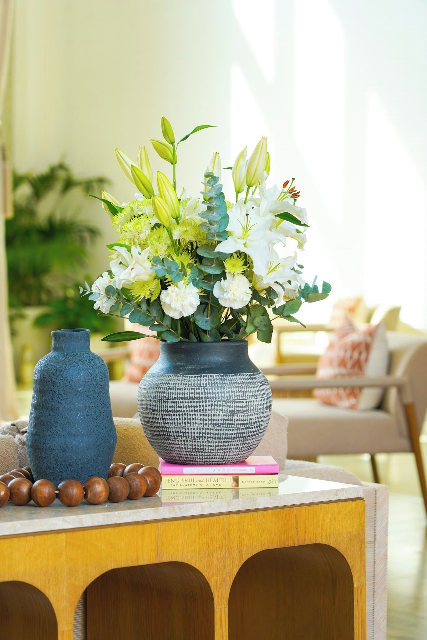 A wooden table with a vase of flowers and a book.