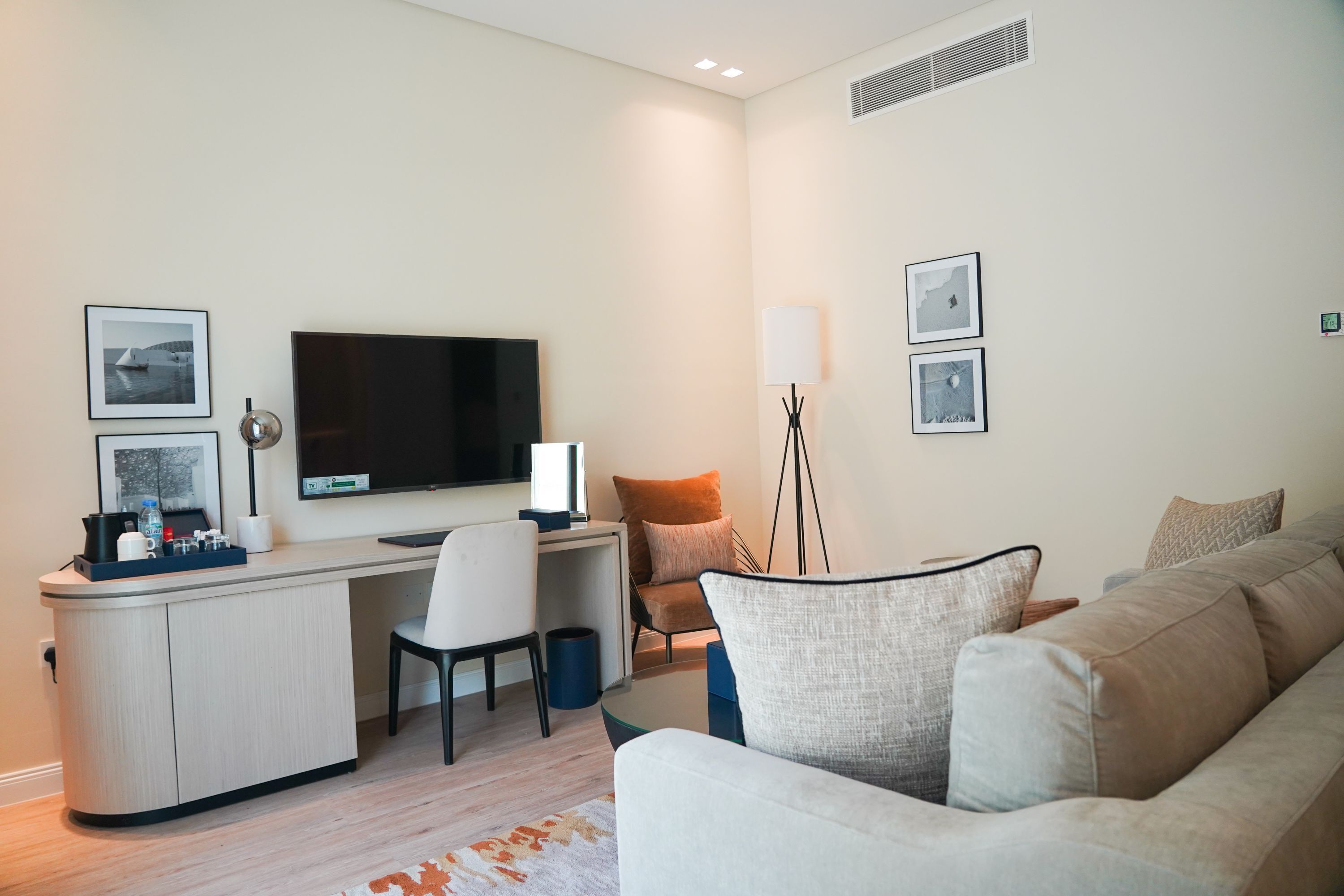 Un salon moderne doté d’un téléviseur à écran plat, d’un bureau et d’un canapé confortable.
