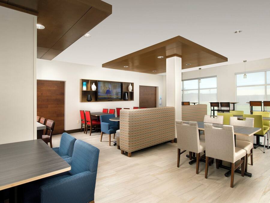A modern interior with a dining area, seating arrangements, and a television screen.