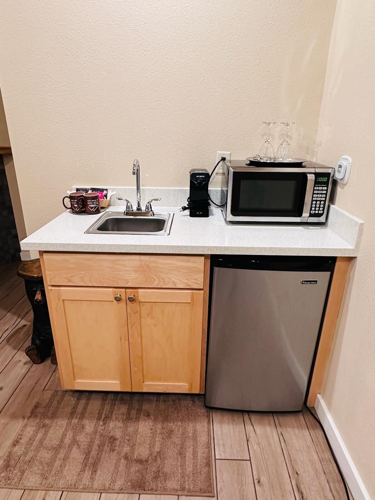 A compact kitchen with a sink, a microwave, and a dishwasher.