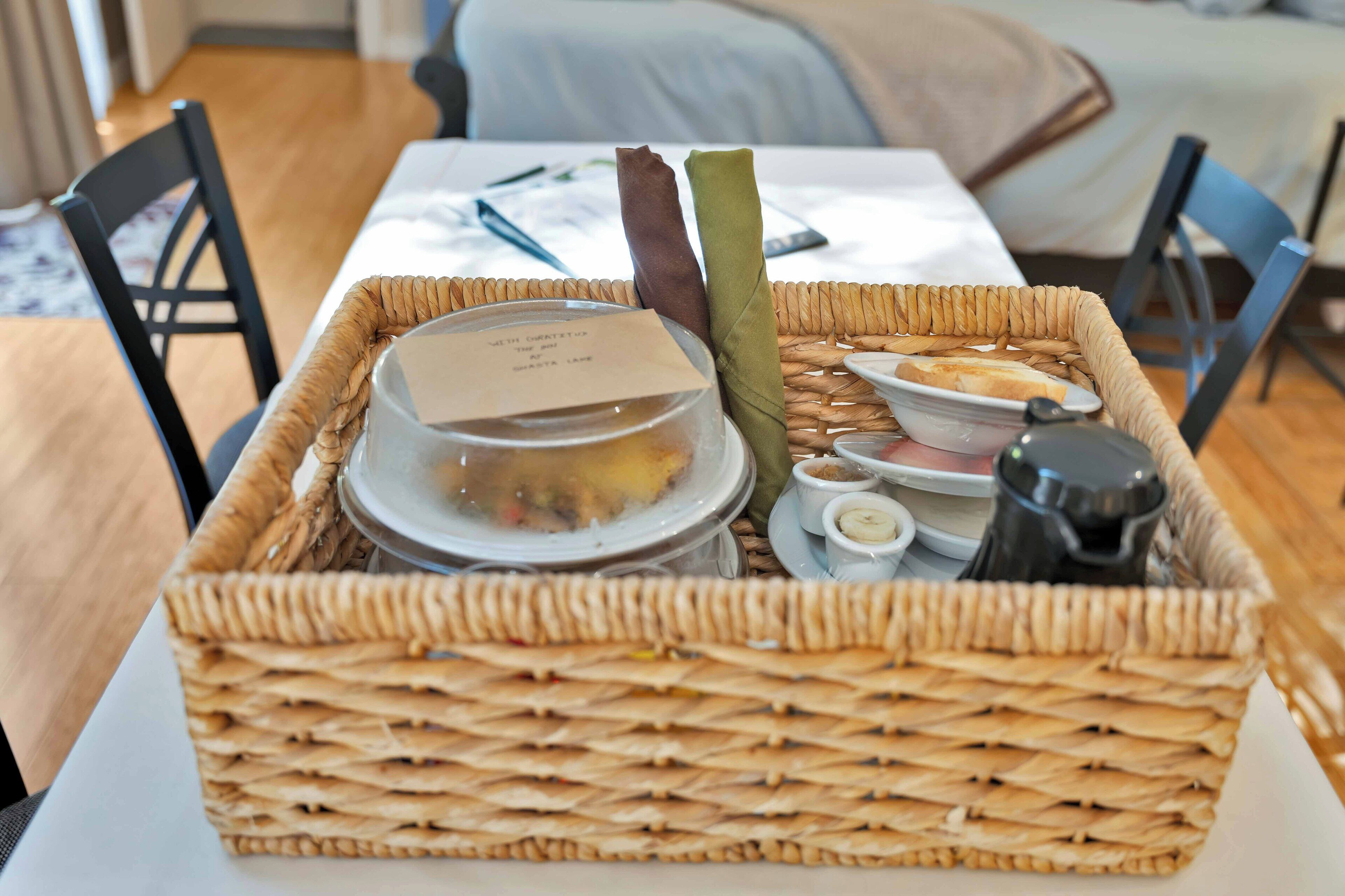 A wicker basket containing food items, a small dish, and a salt shaker on a table.
