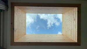 A skylight with a geometric wooden frame and a view of the sky. - Positano in Jeju (Seogwipo)