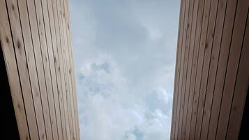 A wooden room with a view of the sky through a window.