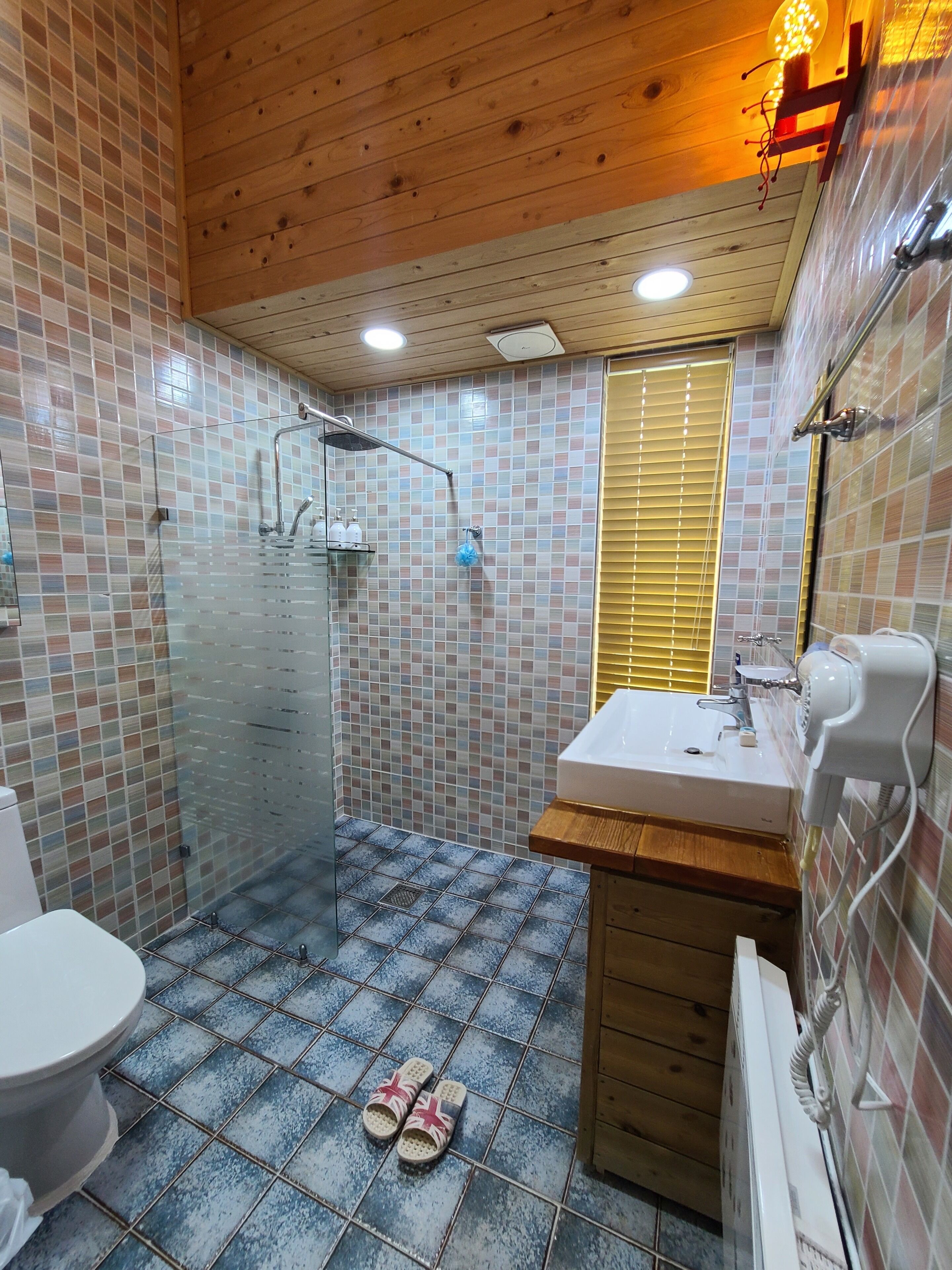 A bathroom with a shower, toilet, and sink.
