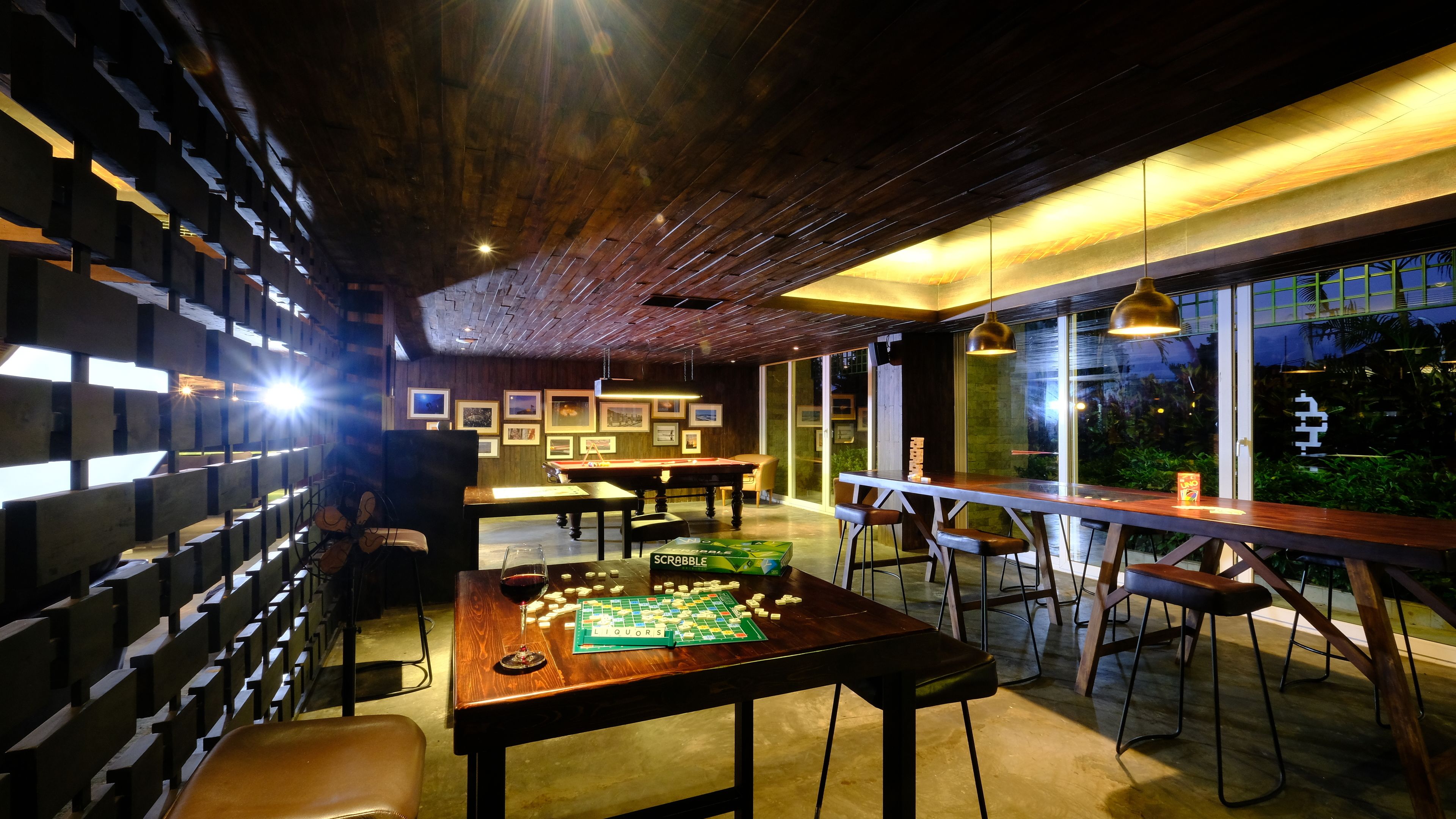 A bar area with a pool table, Scrabble game, and seating.