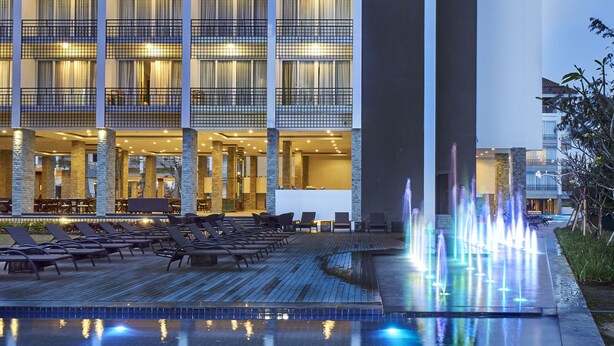 Un hôtel doté d’une piscine, d’un espace extérieur aménagé et d’une fontaine.