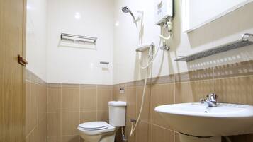 Un baño pequeño y limpio, con inodoro, lavamanos y ducha.