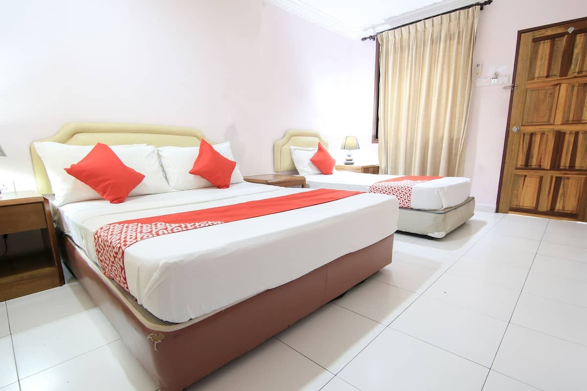 A hotel room with a large bed, a smaller bed, a wooden wardrobe, and a tiled floor.