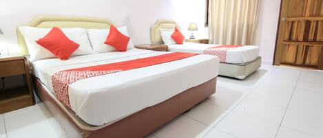 A hotel room with a large bed, two bedside tables, a bedside lamp, and a wooden wardrobe.