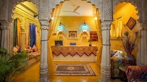 Un hall d’accueil élégant, doté d’un comptoir central, d’arches décoratives et d’un tapis à motifs.