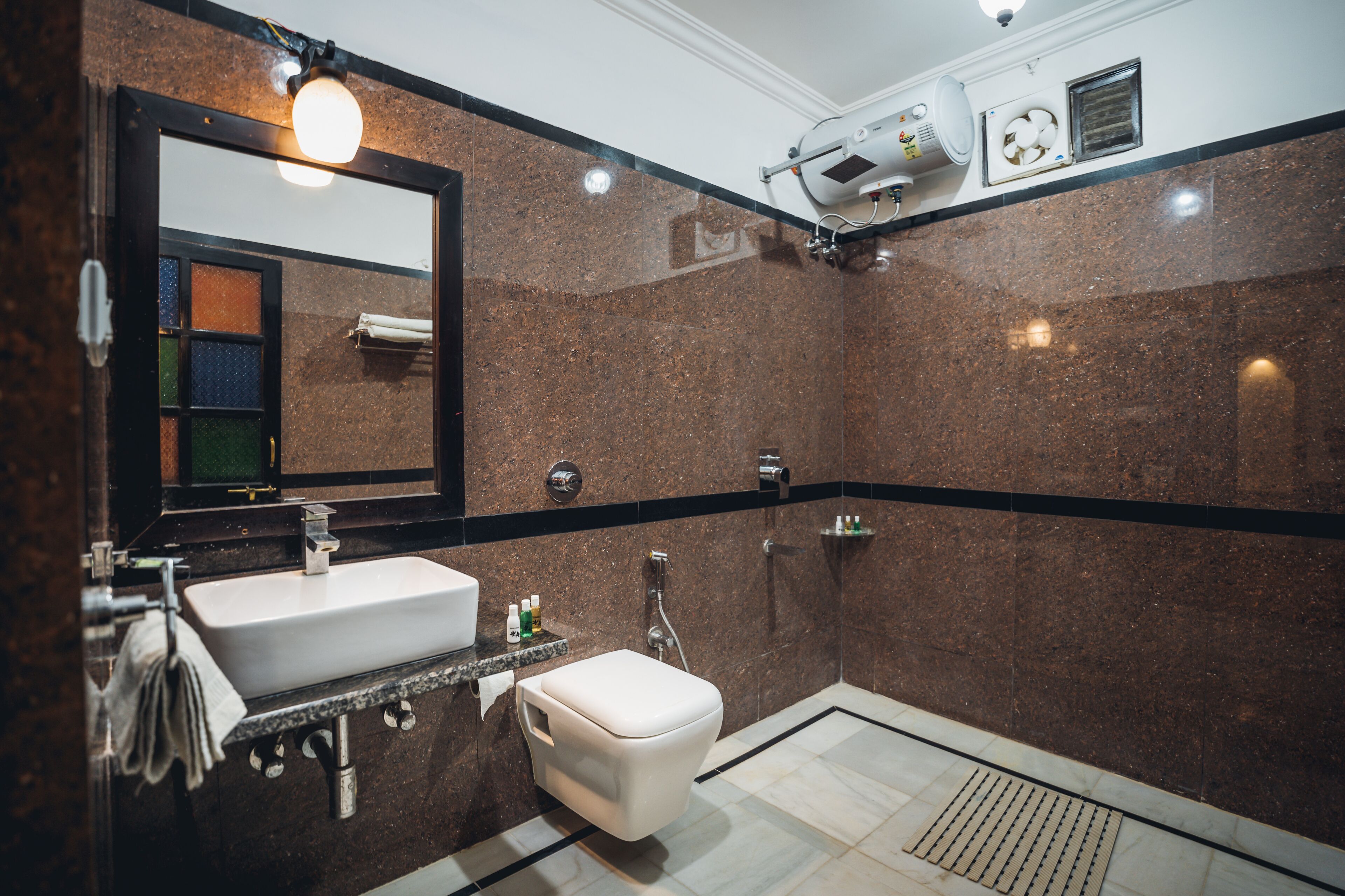 Une salle de bain moderne avec un lavabo blanc, des toilettes et un espace douche.