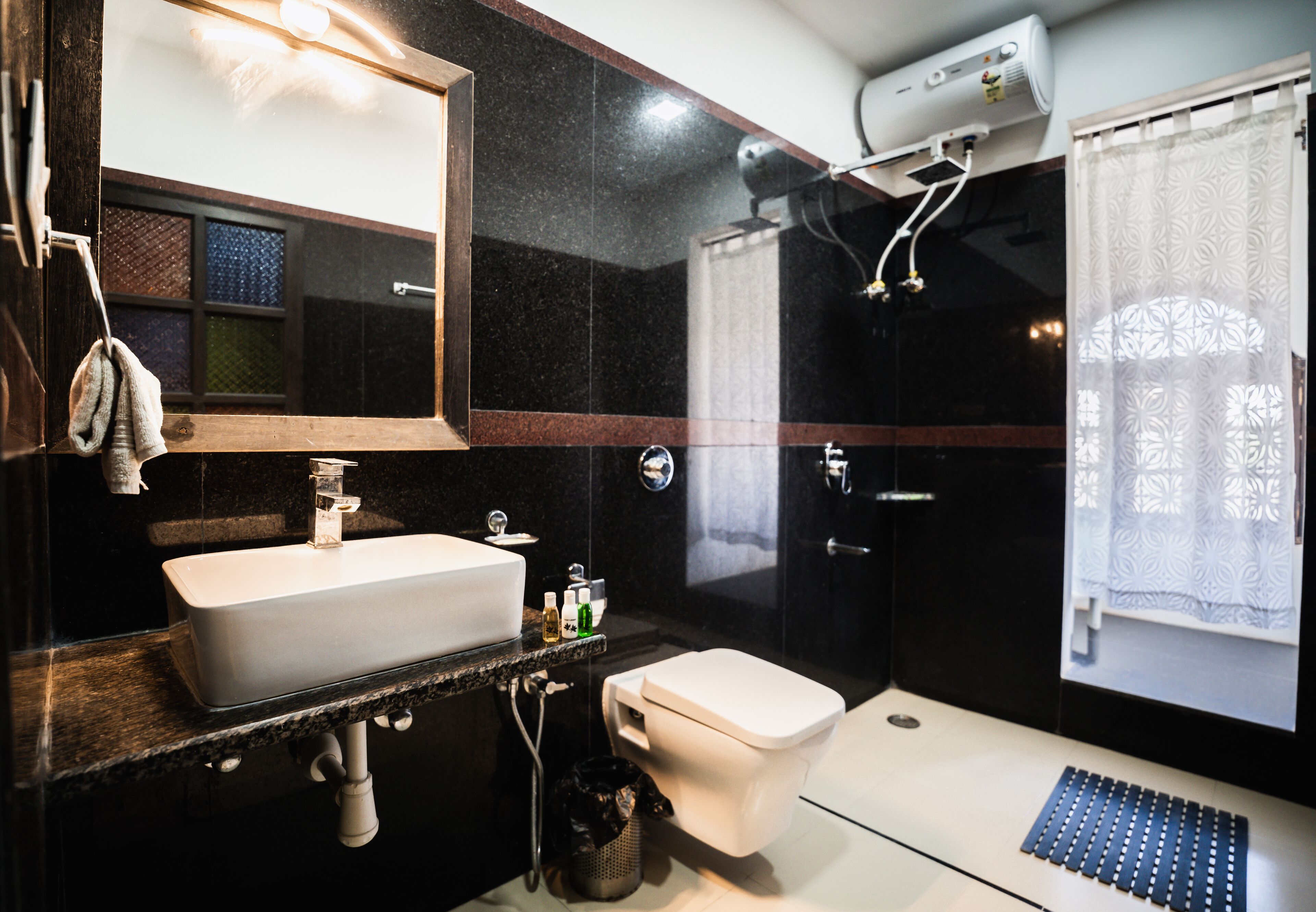 Une salle de bain moderne avec un lavabo blanc, des toilettes et un espace douche.
